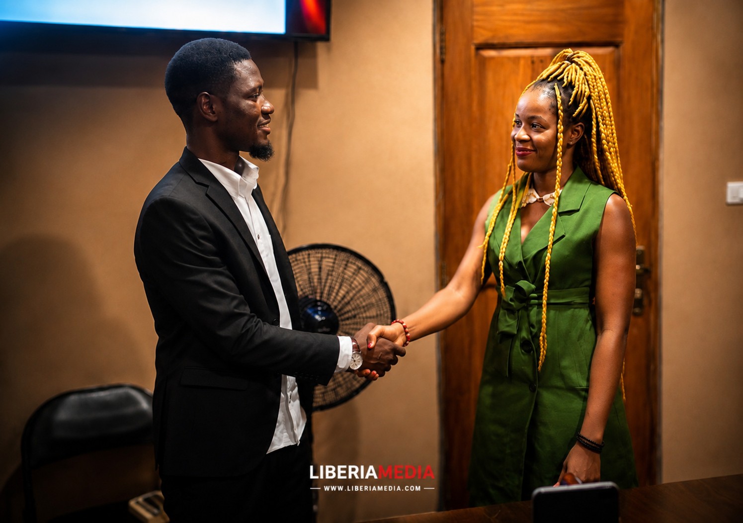 Abdul Karim Sheriff shakes hands with second-place winner Pauline during Liberia competition ceremony