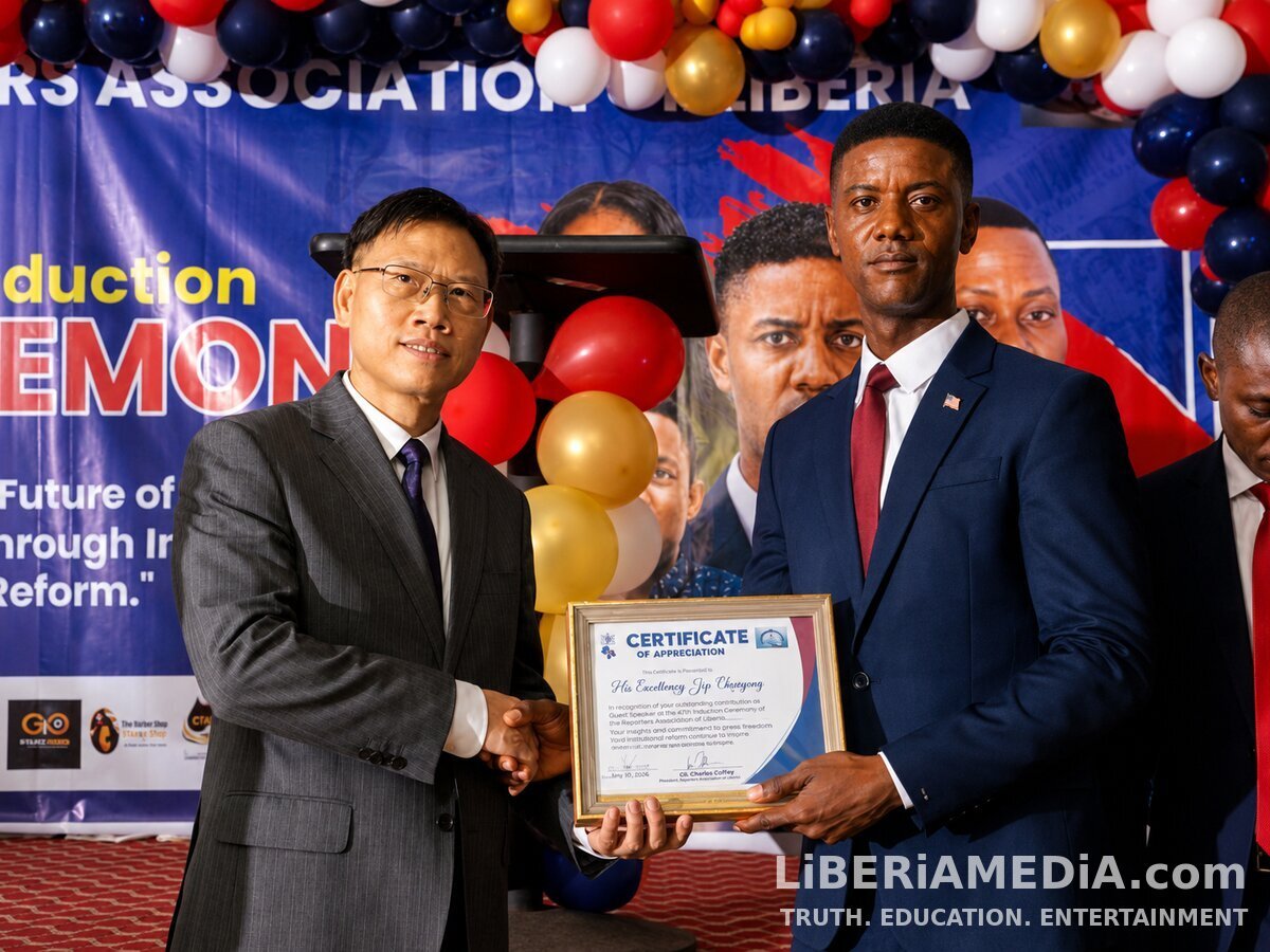 Reporters Association of Liberia President J.H. Webster Clayeh presents a Certificate of Appreciation to the Chinese Ambassador to Liberia during the Association's 7th Induction Ceremony.