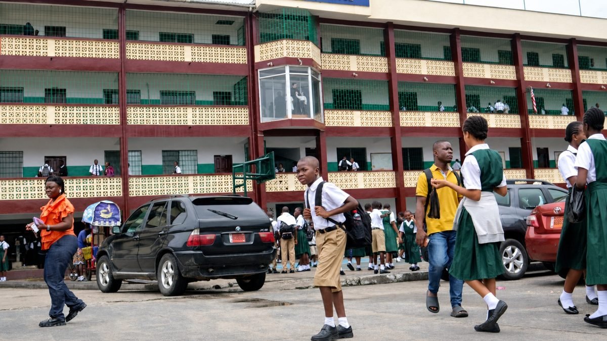 Liberian students in school uniforms gathering outside Don Bosco school building